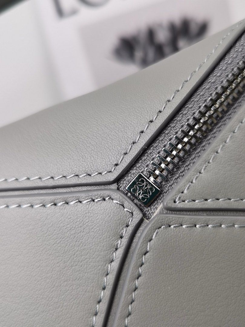 Loewe Puzzle Bag - Grey (Category: Luxury Bags & Wallets) located in Quezon City. Submitted by herluxe_official (Listing ID 1423505494, Image 3). Description: Loewe Medium Puzzle Bag Bought from Hongkong. Dimensions: Medium: (28/29 x 19 x 14 cm) ✈️WE SHIP NATIONWIDE ✅SAME DAY DISPATCH Complete inclusions Dustbag, paperbag, cards and box .