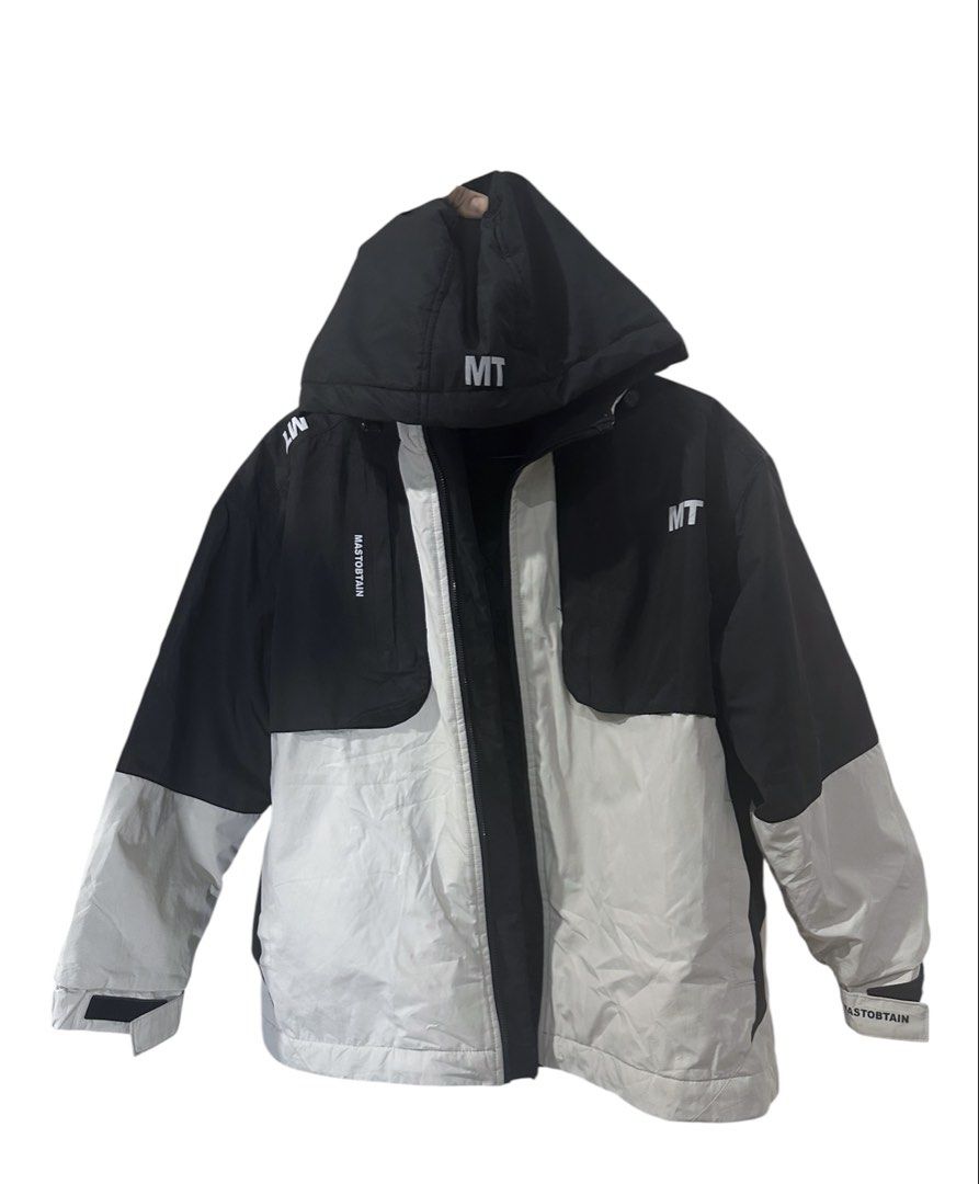 Men MT Color Black Jacket with Hood (Category: Coats, Jackets and Outerwear) located in Manila. Submitted by samzzes (Listing ID 1423436395, Image 1). Description: - Color block design: black and white panels - Features a hood - "MT" logo on front and hood - Full-zip closure - Cuffs with "RASTOBTAIN" print - Suitable for winter.