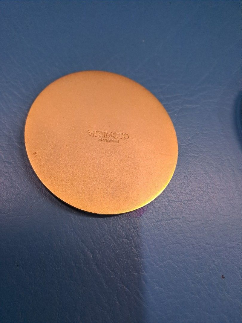 Mikimoto Compact Mirror (Category: Mirrors) located in Manila. Submitted by joanbalde39643 (Listing ID 1423531594, Image 2). Description: Mikimoto compact mirror with a gold-toned frame and decorative swirls. The back of the mirror is also gold-toned and has the Mikimoto brand name. A small, portable mirror perfect for on-the-go touch-ups. Mikimoto compact mirrors typically range in price from $28.00 to $250.00, depending on the design, materials