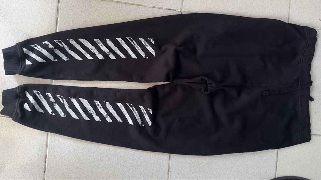 Off-White Black Sweatpants (Category: Joggers) located in Padre Garcia. Submitted by dripden_ph (Listing ID 1423468813, Image 2). Description: - Off-White sweatpants - White stripes on legs - "WHITE" printed on cuffs - Drawstring waist - Soft, comfortable material - Size tag visible - Perfect for casual wear -34x42.