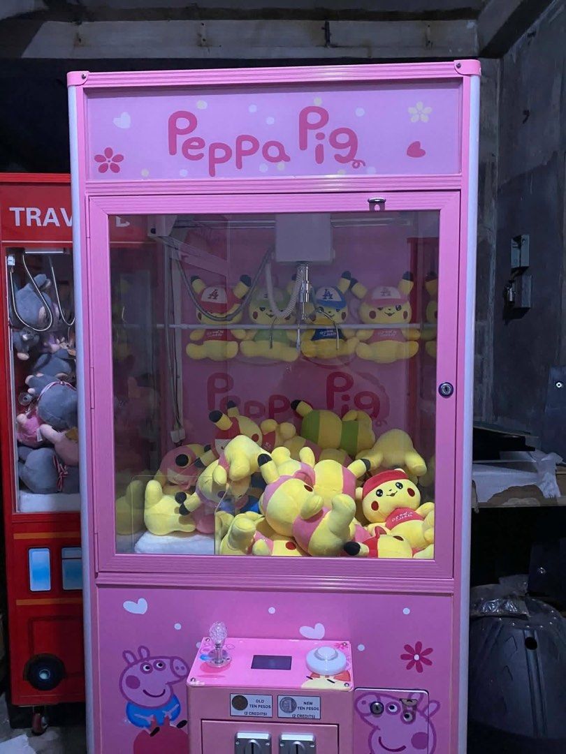 Peppa Pig Claw Machine (Category: Kids Toys) located in San Pablo. Submitted by vennisa.sportssupplies (Listing ID 1423503497, Image 2). Description: - Peppa Pig claw machine - Features a pink exterior with Peppa Pig graphics - Filled with plush toys - Coin slot operation - Mounted on wheels for easy movement - Great for home or business use.