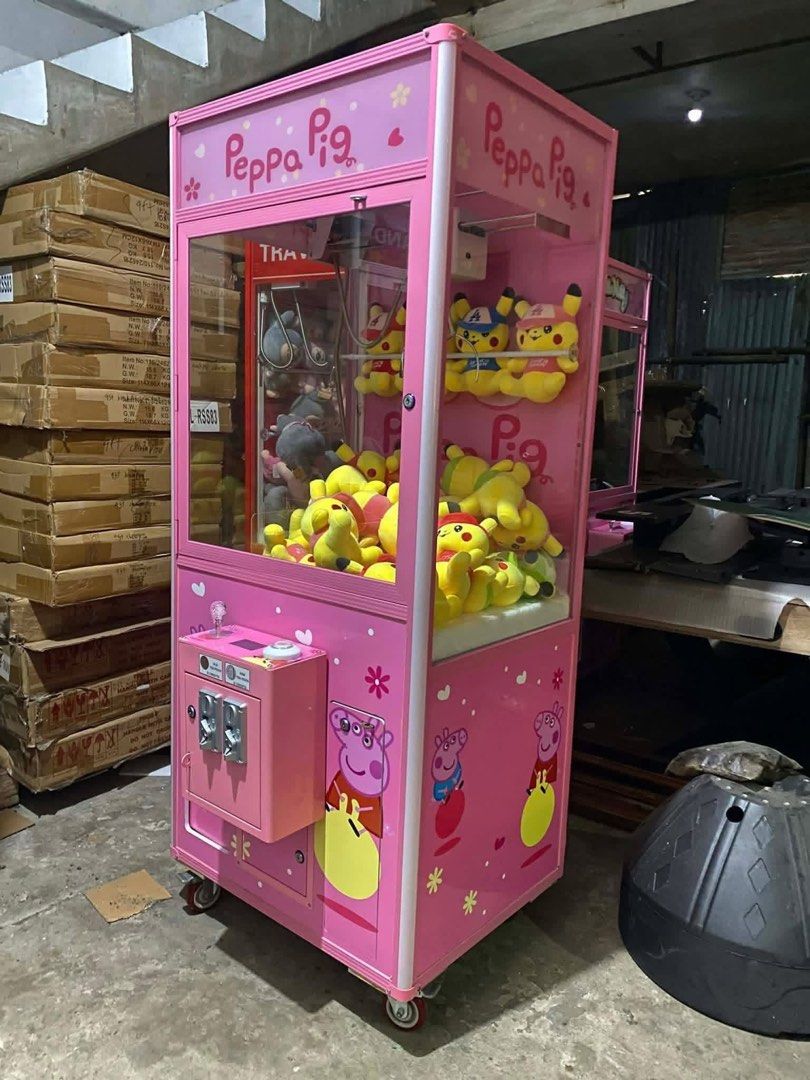 Peppa Pig Claw Machine (Category: Kids Toys) located in San Pablo. Submitted by vennisa.sportssupplies (Listing ID 1423503497, Image 1). Description: - Peppa Pig claw machine - Features a pink exterior with Peppa Pig graphics - Filled with plush toys - Coin slot operation - Mounted on wheels for easy movement - Great for home or business use.