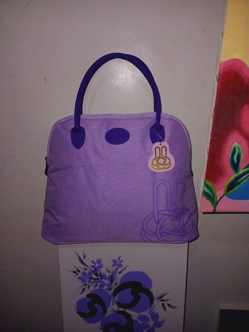 Purple Handbag alma style (Category: Luxury Bags & Wallets) located in Rodriguez. Submitted by maycol (Listing ID 1423591349, Image 2). Description: - Purple handbag with a unique design - Features a circular accent - Decorative element on the front - Made of fabric - Matching purple handle - Stylish accessory for everyday use.