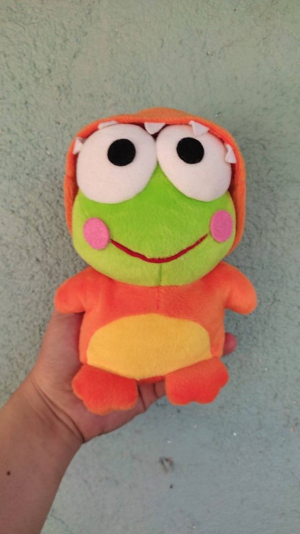 Sanrio Keroppi Plush Toy (Category: Plushies & Soft Toys) located in Tarlac. Submitted by maxgar16638 (Listing ID 1423539109, Image 1). Description: - Adorable Keroppi plush toy - Dressed in an orange outfit - Features a green face, large eyes, and pink cheeks - Made in China - Includes a Sanrio Co., Ltd. tag from 1988, 1998 - Perfect for collectors and gifts.
