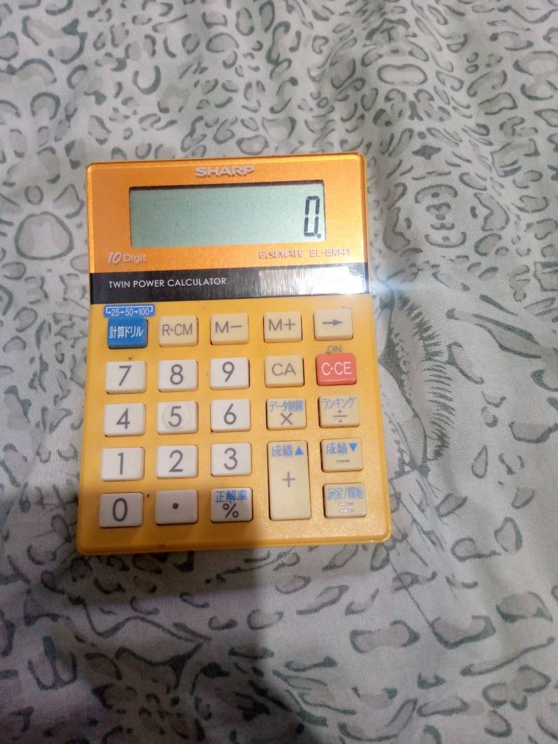 Vintage Sharp ELSI MATE EL-BM41 Calculator (Category: Office & Business Technology) located in Imus. Submitted by chadrich_05 (Listing ID 1423443011, Image 3). Description: - Vintage Sharp ELSI MATE EL-BM41 calculator. - 10-digit display. - Twin power functionality. - Features basic arithmetic functions. - Includes specialized buttons with Japanese characters. - Compact and functional design. - Yellow body with white buttons..