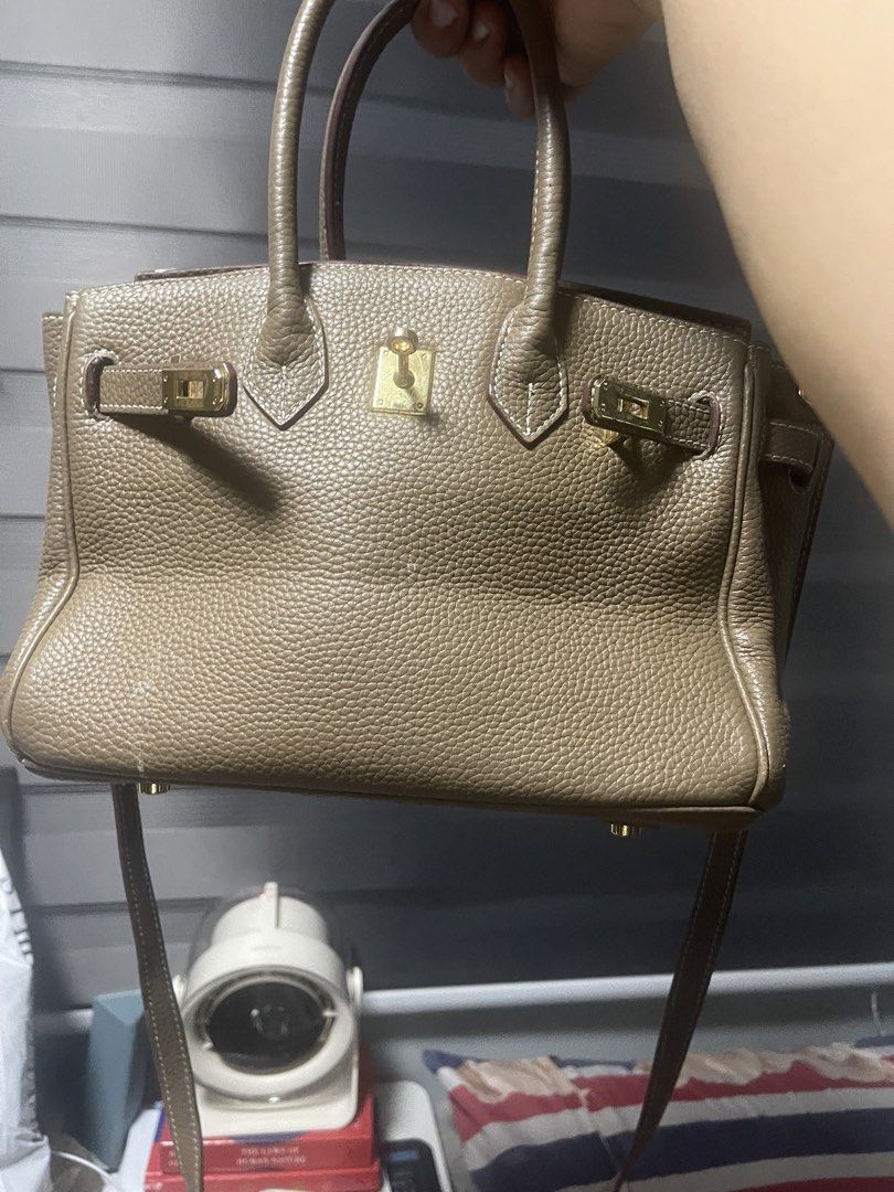 Taupe Leather Handbag with Shoulder Strap (Category: Shoulder Bags) located in Manila. Submitted by dnash29 (Listing ID 1423567726, Image 2). Description: - Taupe leather handbag - Structured design - Top handle and detachable shoulder strap - Gold-tone clasp and hardware - Interior pocket - Textured leather exterior - Visible stitching - Classic style.