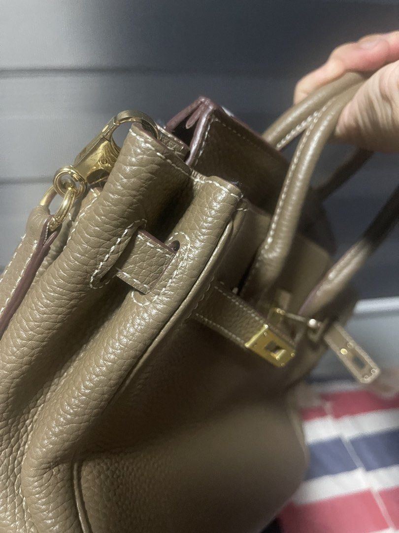 Taupe Leather Handbag with Shoulder Strap (Category: Shoulder Bags) located in Manila. Submitted by dnash29 (Listing ID 1423567726, Image 3). Description: - Taupe leather handbag - Structured design - Top handle and detachable shoulder strap - Gold-tone clasp and hardware - Interior pocket - Textured leather exterior - Visible stitching - Classic style.