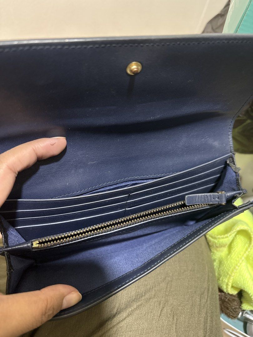 Tory Burch Black Wallet (Category: Luxury Bags & Wallets) located in Pasig City. Submitted by dyclutterwithme (Listing ID 1423576906, Image 3). Description: Preloved Tory Burch black wallet. Features card slots, zippered compartment, and snap closure. Includes original shopping bag. 🌸 Note ‼️ Please check latter photos for signs of peeling on the sides. Not obvious naman and I think you can cut them out na lang or glue them back if ever. RFS: De