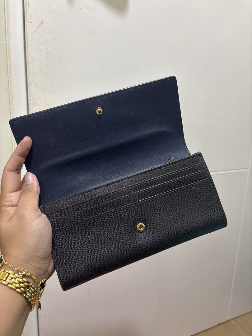 Tory Burch Black Wallet (Category: Luxury Bags & Wallets) located in Pasig City. Submitted by dyclutterwithme (Listing ID 1423576906, Image 2). Description: Preloved Tory Burch black wallet. Features card slots, zippered compartment, and snap closure. Includes original shopping bag. 🌸 Note ‼️ Please check latter photos for signs of peeling on the sides. Not obvious naman and I think you can cut them out na lang or glue them back if ever. RFS: De