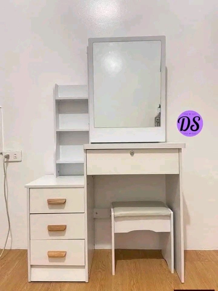Vanity Table with Mirror and Stool (Category: Tables & Sets) located in Makati City. Submitted by oideme (Listing ID 1423534465, Image 2). Description: Vanity table features a mirror, a stool, and multiple drawers for storage. It has a built-in shelf unit on the side for additional storage. The table is available in various colors, including pink and white, and wood finishes. It's a great addition to any bedroom or dressing area..