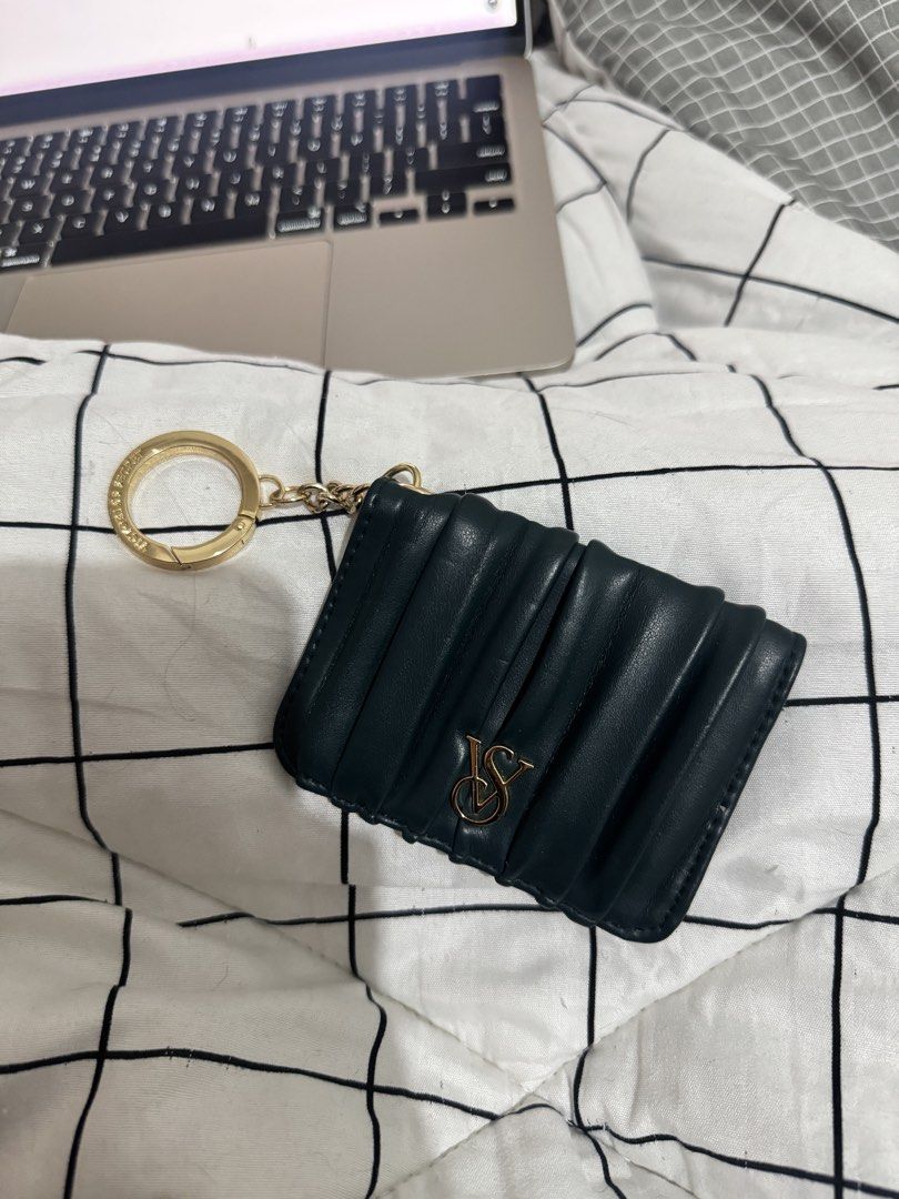 Victoria's Secret Card Holder (Category: Wallets & Card holders) located in San Fernando. Submitted by alt_thea (Listing ID 1423554641, Image 1). Description: - Dark green card holder - Gold-tone key ring - Victoria's Secret logo - Multiple card slots - Clear ID window - Snap closure - Textured material - brand new mop: gcash or bank mod: jrs/lalamove.