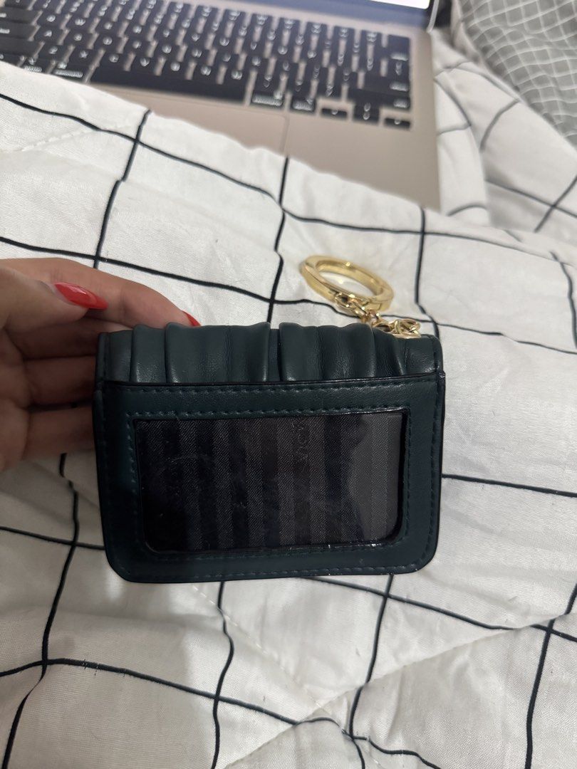 Victoria's Secret Card Holder (Category: Wallets & Card holders) located in San Fernando. Submitted by alt_thea (Listing ID 1423554641, Image 3). Description: - Dark green card holder - Gold-tone key ring - Victoria's Secret logo - Multiple card slots - Clear ID window - Snap closure - Textured material - brand new mop: gcash or bank mod: jrs/lalamove.