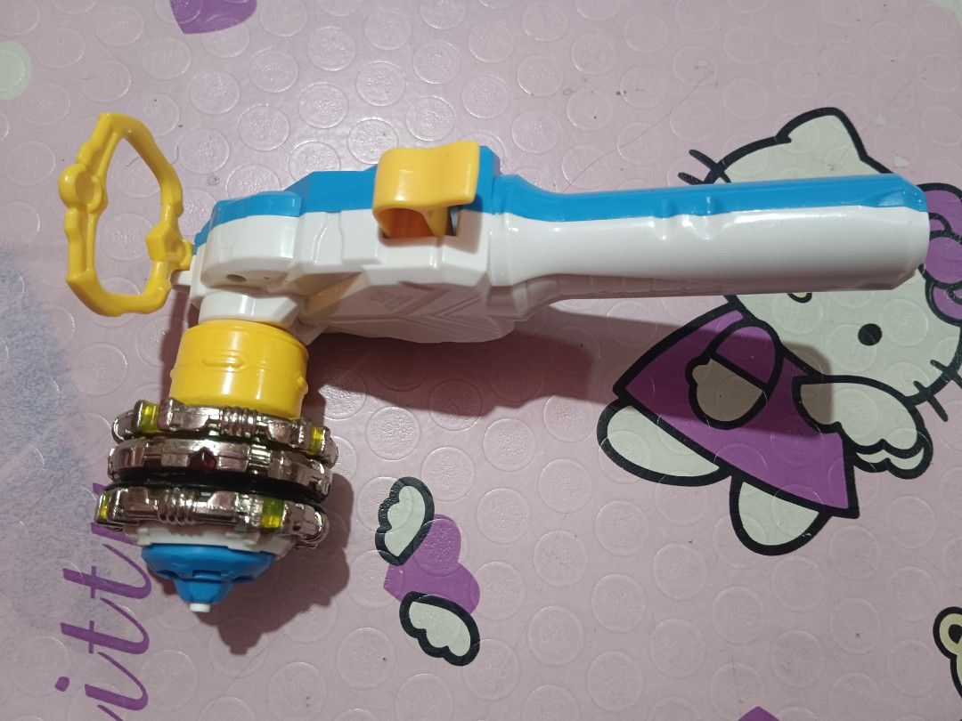 Beyblade Burst auldey Launcher and Tops Set (Category: Action & Battle Toys) located in Pasig City. Submitted by rednaxela_rich (Listing ID 1423714609, Image 1). Description: - Beyblade Burst set for immediate play! - Includes a white and blue launcher with yellow accents. - Comes with three Beyblade tops in red, blue, and yellow. - Complete set..