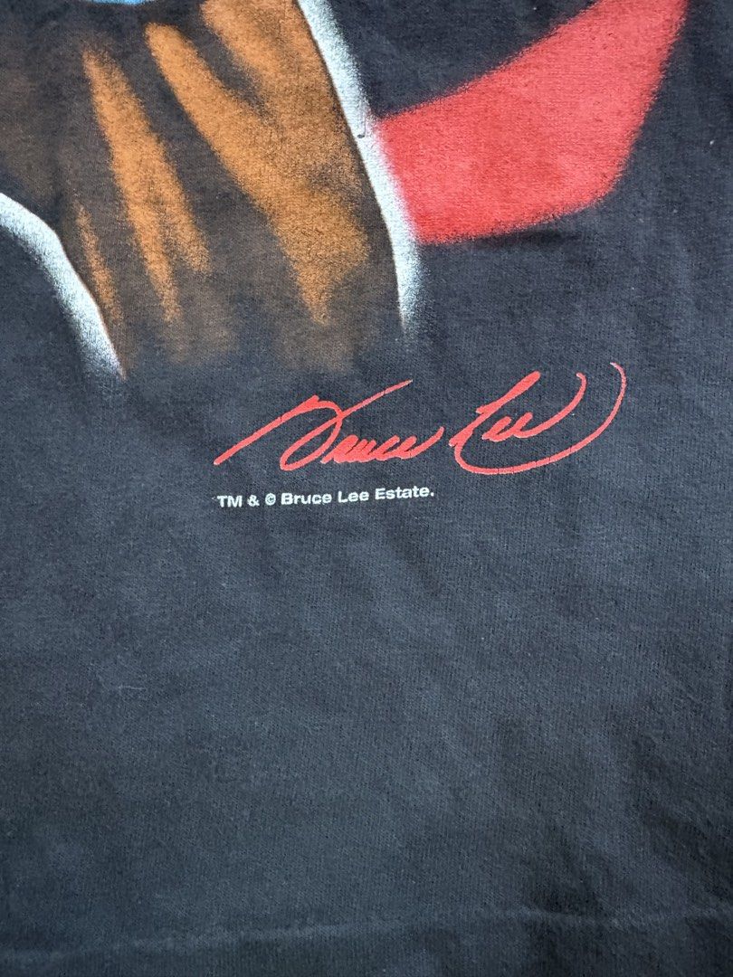 Bruce Lee Vintage T-Shirt (Category: Tshirts & Polo Shirts ) located in Lipa City. Submitted by thriftopia_sj (Listing ID 1423664999, Image 3). Description: - Vintage Bruce Lee t-shirt - Features a front graphic of Bruce Lee in a blue outfit with red Chinese characters - Back of shirt has the Bruce Lee logo in red - From the Bruce Lee Estate - Tag: Changes 20x28 Changes Tag.