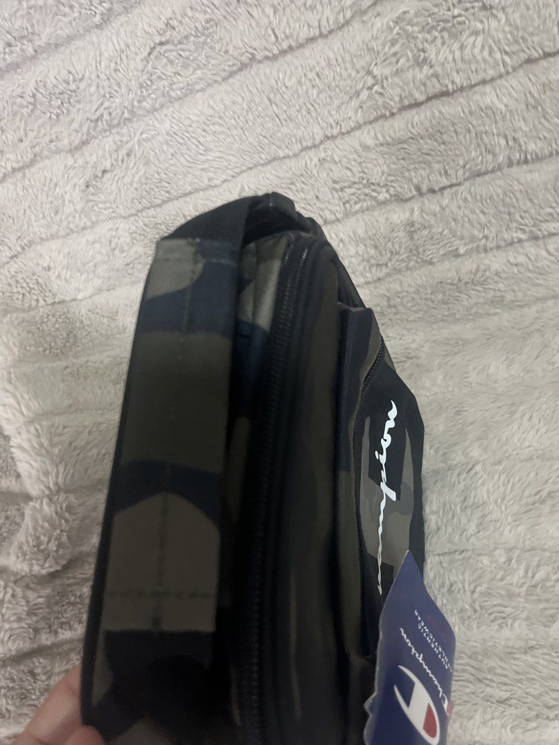 Champion Camo Lunch Bag (Category: Sling Bags) located in Pasig City. Submitted by jundbaptist21 (Listing ID 1423687549, Image 3). Description: - Champion camouflage lunch bag - Insulated interior - Zippered front pocket - Top handle - Black base with Champion logo - Buckle closure on the side - Includes Champion tag -on sale.
