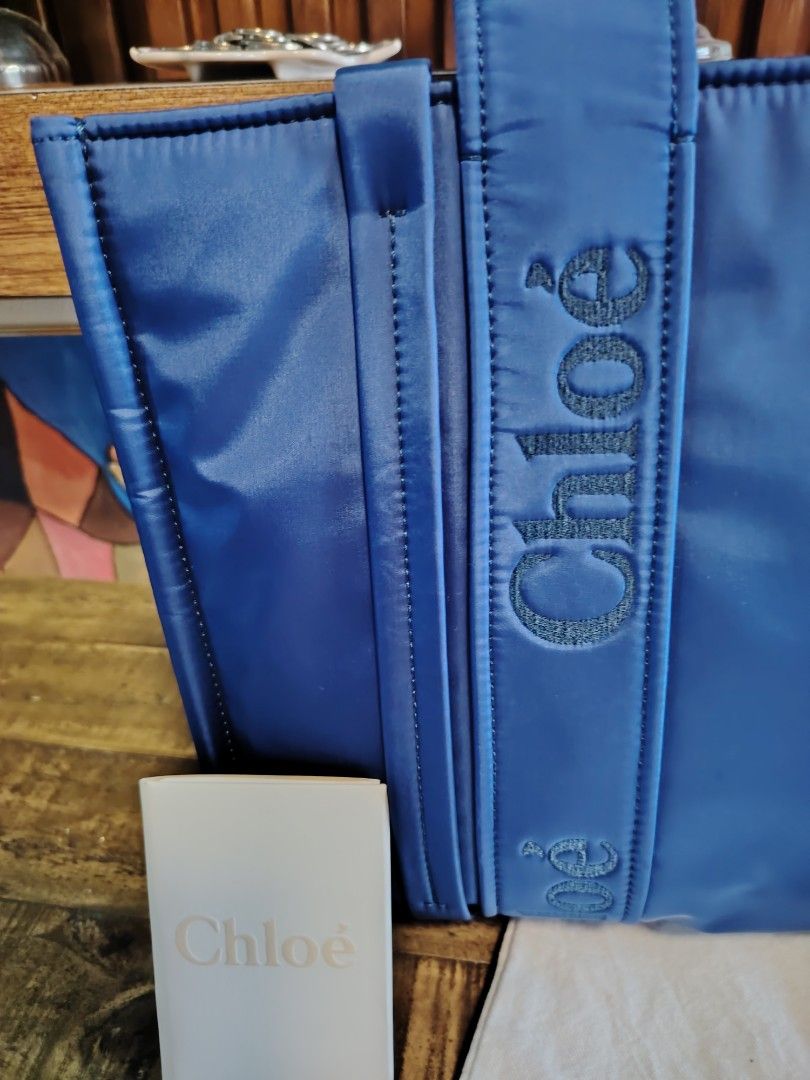 Chloe Woody Tote Bag (Category: Luxury Bags & Wallets) located in Imus. Submitted by angelworks (Listing ID 1423676450, Image 2). Description: - Authentic Chloe Woody tote bag in NYKIN - Vibrant blue color - Chloe logo embroidered on handles - Includes interior pocket - Comes with dust bag and Chloe card - Digital ID tag inside - Perfect for everyday use -LIKE NEW.