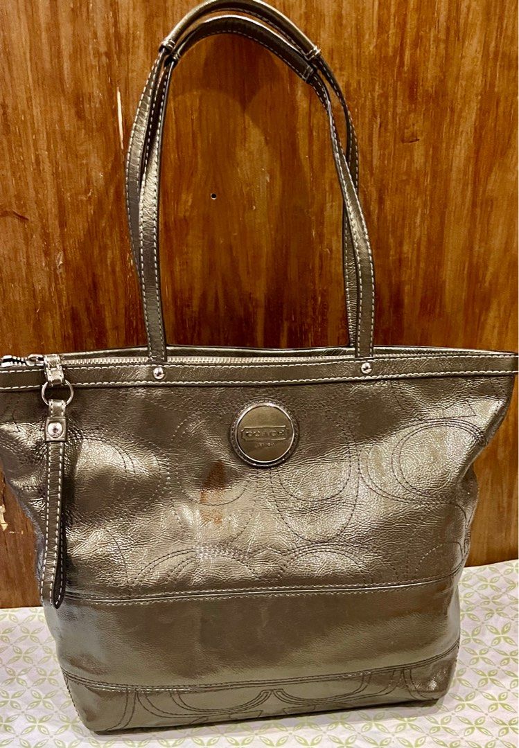 Coach Metallic Tote Bag (Category: Luxury Bags & Wallets) located in Manila. Submitted by gee0505 (Listing ID 1423782393, Image 1). Description: - Coach metallic tote bag - Zip closure - Interior pockets - Coach logo emblem - Light blue fabric lining - Model number: F15142 - Exterior shows staining.