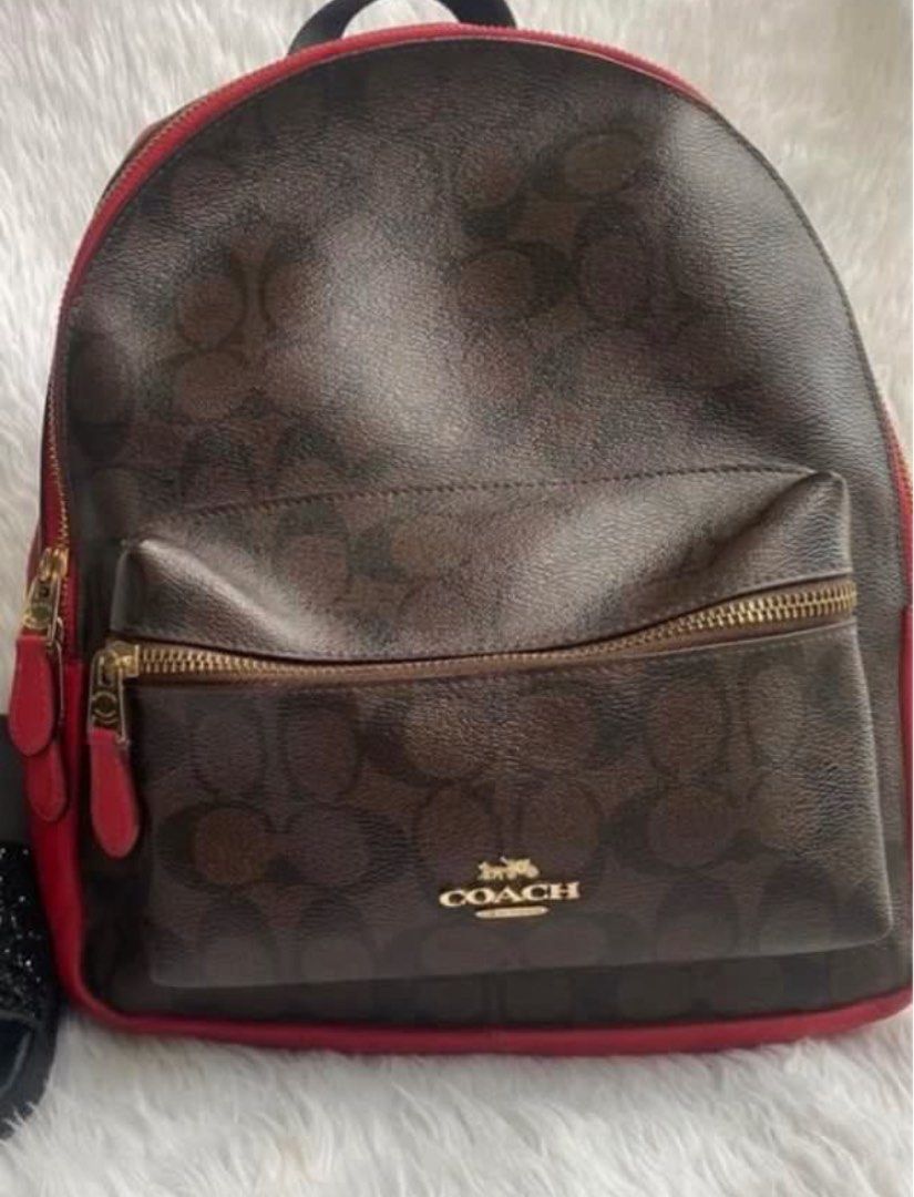 Coach Signature Backpack (Category: Luxury Bags & Wallets) located in Pasig City. Submitted by karenrules (Listing ID 1423617219, Image 1). Description: - Authentic Coach backpack - Signature brown pattern with red accents - Front pocket with gold zipper - Red interior - Gold zippers - Red leather detailing on sides - Interior zippered pocket - Includes Coach tag.