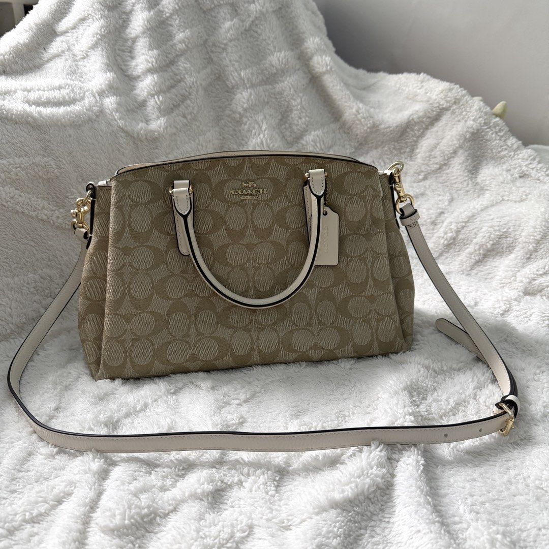 Coach Signature Satchel Handbag (Category: Luxury Bags & Wallets) located in Bulacan. Submitted by klutterbykoko (Listing ID 1423679546, Image 1). Description: - Authentic Coach satchel - Classic Coach signature pattern - Cream-colored accents - Detachable shoulder strap - Top handle - Spacious interior with multiple compartments - Gold-tone hardware - Coach hangtag - Light brown fabric lining.