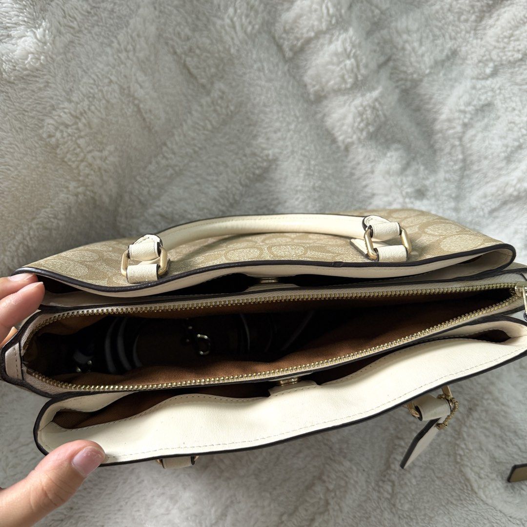 Coach Signature Satchel Handbag (Category: Luxury Bags & Wallets) located in Bulacan. Submitted by klutterbykoko (Listing ID 1423679546, Image 2). Description: - Authentic Coach satchel - Classic Coach signature pattern - Cream-colored accents - Detachable shoulder strap - Top handle - Spacious interior with multiple compartments - Gold-tone hardware - Coach hangtag - Light brown fabric lining.