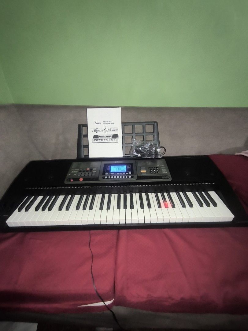 Davis D-816 Digital Keyboard (Category: Musical Instruments) located in Manila. Submitted by bonsai13 (Listing ID 1423694717, Image 2). Description: -Davis 816 Digital Keyboard -61 Touch Sensitive Keys -Light Up Keys -Built in teaching programs -Like new with Box -Bought Feb 20, 2026 -Still under warranty -Includes a music score, power adapter, and a music stand. -The keyboard has a black body with white and black keys..