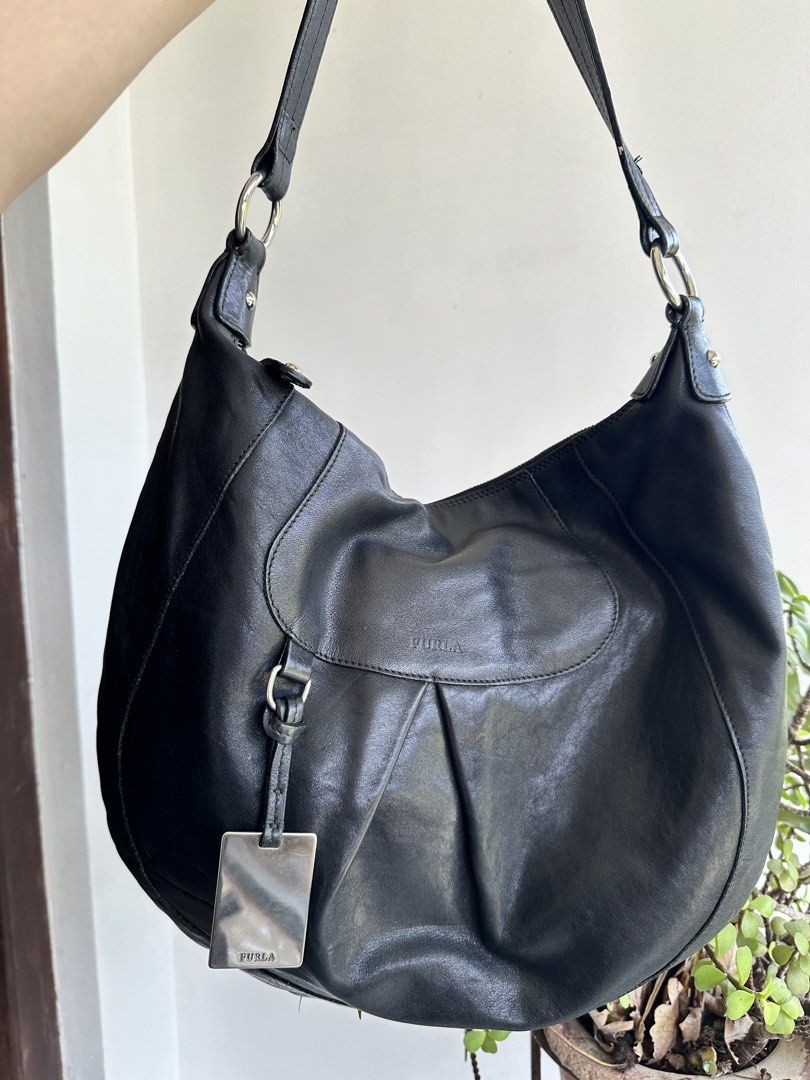 Furla Black Leather Hobo Bag (Category: Luxury Bags & Wallets) located in Bombon. Submitted by cookiespreloveed (Listing ID 1423751256, Image 1). Description: - Furla black leather hobo bag - Silver-tone metal tag and hardware - Secure zipper closure - Spacious interior with Furla logo lining - Comfortable shoulder strap - Durable YKK zipper.