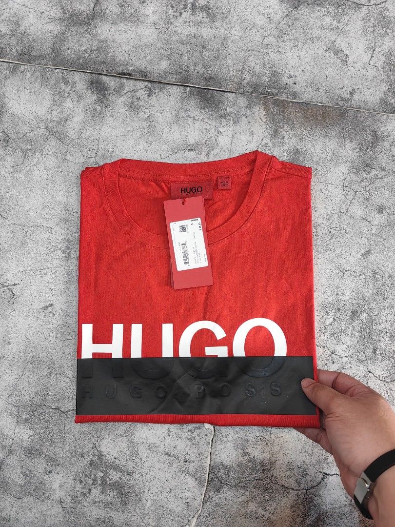 Hugo Boss Red T-Shirt (Category: Tshirts & Polo Shirts ) located in Quezon City. Submitted by 110collectionsph (Listing ID 1423767671, Image 2). Description: PAMIGAY PRESYO NEW DROP ‼️ STEAL PRICE B0SS PROMINENT BLACK BOX LOGO T-SHIRT | SMALL ONLY | P3,298 Available online and in-store. Small shop location Cubao Quezon City - Red Hugo Boss T-shirt - White "HUGO" logo on chest - Black horizontal stripe with embossed branding - Unworn condition - I