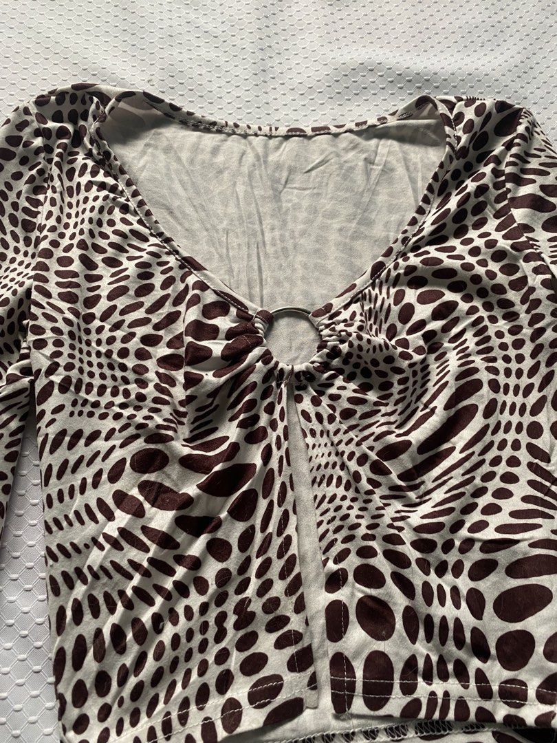 Long Sleeve Crop Top with Ring Detail (Category: Blouses) located in Santa Rita. Submitted by jayiwishes (Listing ID 1423660703, Image 2). Description: Brown & white patterned crop top with V-neck and ring detail. Fitted silhouette, long sleeves. Pair with high-waisted bottoms..