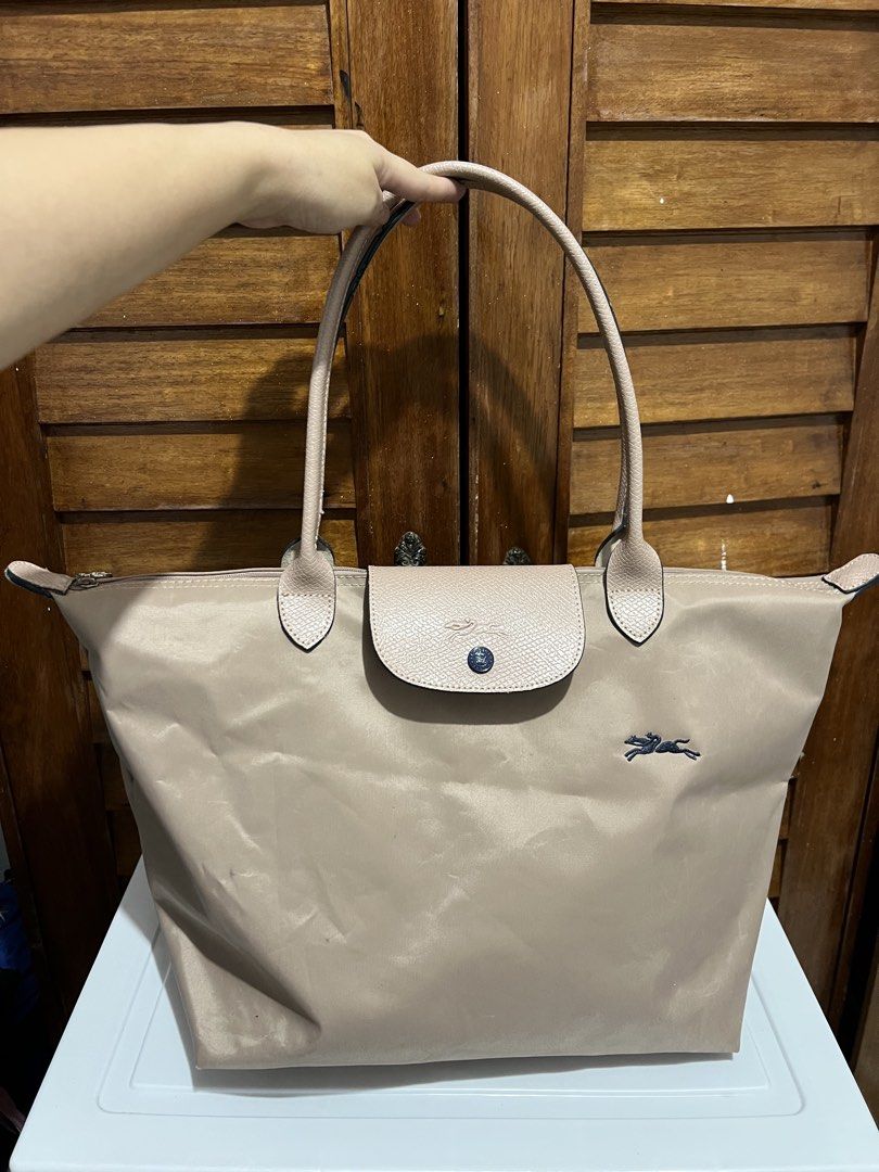 Longchamp Le Pliage Tote Bag (Category: Luxury Bags & Wallets) located in Manila. Submitted by zoeykim16 (Listing ID 1423678598, Image 1). Description: - Longchamp Le Pliage tote bag - Neutral beige color - Flap closure with snap button - Features Longchamp logo - Two handles - Spacious interior with pockets - Made of durable nylon - Ideal for everyday use.