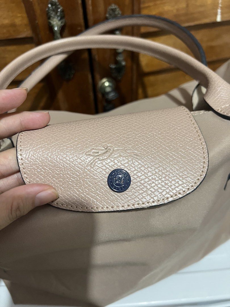 Longchamp Le Pliage Tote Bag (Category: Luxury Bags & Wallets) located in Manila. Submitted by zoeykim16 (Listing ID 1423678598, Image 3). Description: - Longchamp Le Pliage tote bag - Neutral beige color - Flap closure with snap button - Features Longchamp logo - Two handles - Spacious interior with pockets - Made of durable nylon - Ideal for everyday use.