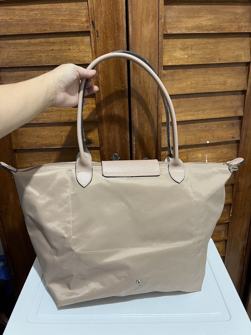 Longchamp Le Pliage Tote Bag (Category: Luxury Bags & Wallets) located in Manila. Submitted by zoeykim16 (Listing ID 1423678598, Image 2). Description: - Longchamp Le Pliage tote bag - Neutral beige color - Flap closure with snap button - Features Longchamp logo - Two handles - Spacious interior with pockets - Made of durable nylon - Ideal for everyday use.