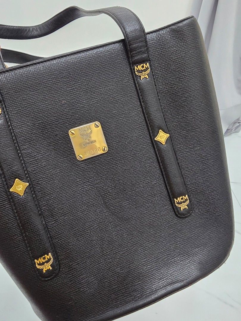 MCM Black Tote Bag (Category: Luxury Bags & Wallets) located in Las Pinas. Submitted by vanpru (Listing ID 1423778655, Image 2). Description: MCM mini tote bag Made in korea With signs of usage and creases but still good 2k - Authentic MCM tote bag - Color: Black - Hardware: Gold-tone - Closure: Top zipper - Interior pocket - Handles: Two - Shape: Rectangular - MCM logo visible - Made in Korea.