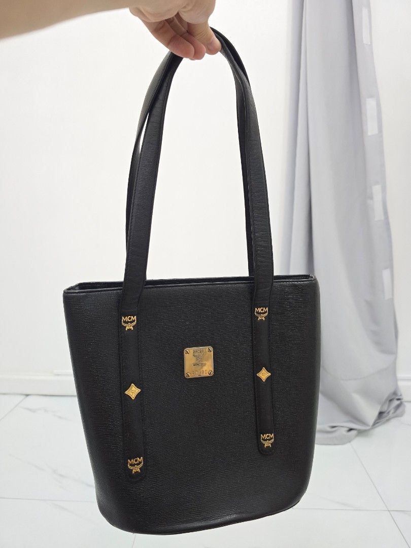 MCM Black Tote Bag (Category: Luxury Bags & Wallets) located in Las Pinas. Submitted by vanpru (Listing ID 1423778655, Image 1). Description: MCM mini tote bag Made in korea With signs of usage and creases but still good 2k - Authentic MCM tote bag - Color: Black - Hardware: Gold-tone - Closure: Top zipper - Interior pocket - Handles: Two - Shape: Rectangular - MCM logo visible - Made in Korea.