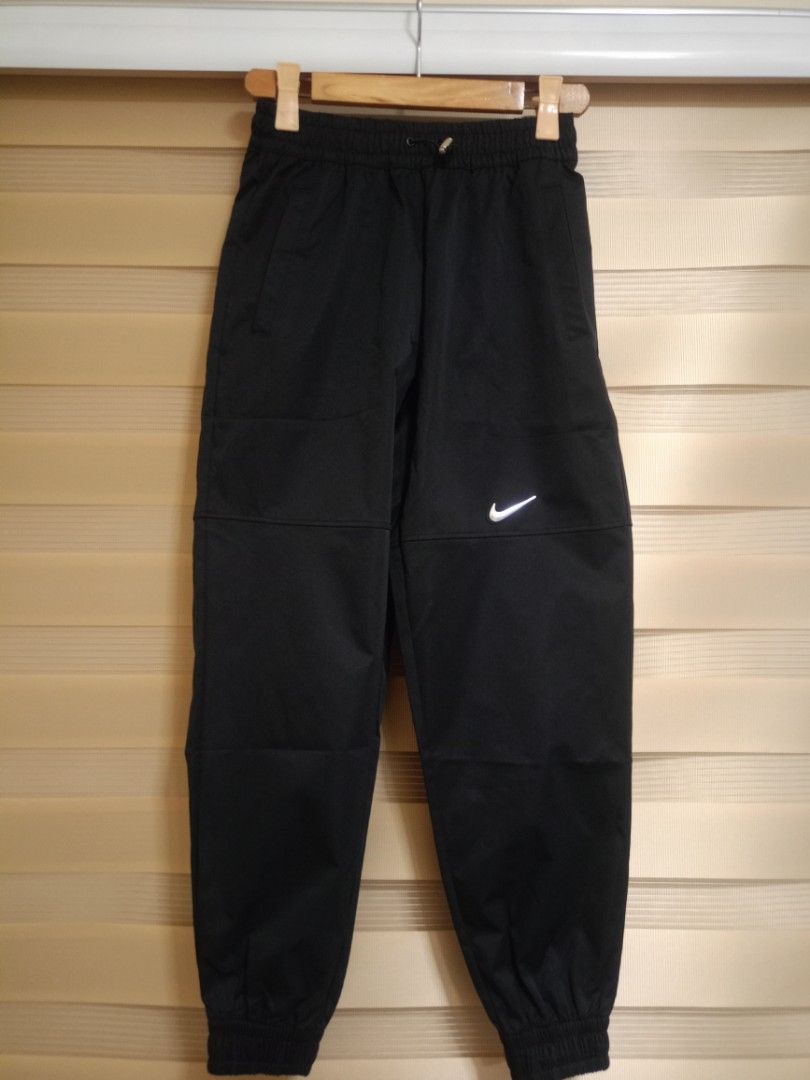 Nike Swoosh Woven Pants - Size S (Category: Joggers) located in Valenzuela. Submitted by One.Only.Nan (Listing ID 1423746994, Image 1). Description: Black Nike pants with an elastic waistband and drawstring. Features the Nike logo on the front. Includes pockets and elastic cuffs at the ankles. Made in China. Size S. Fits 28-30usm Length 38" MOP: GCASH MAYA AUB BPI VALENZUELA CITY LOC .