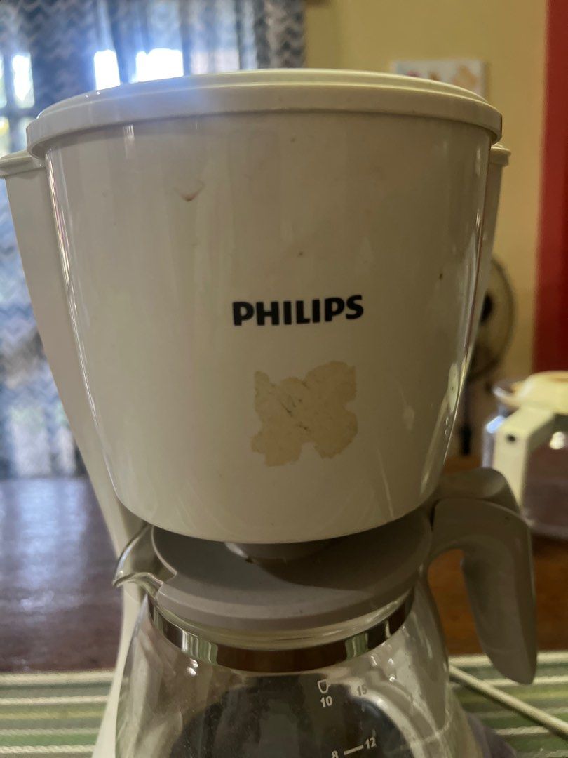Philips Coffee Maker (Category: Coffee Machines & Makers) located in San Pedro. Submitted by mighty_oh (Listing ID 1423616804, Image 3). Description: - Philips coffee maker - Glass carafe - Power button - Water level indicator - Visible filter basket - White exterior (some discoloration) - Two-pin plug.