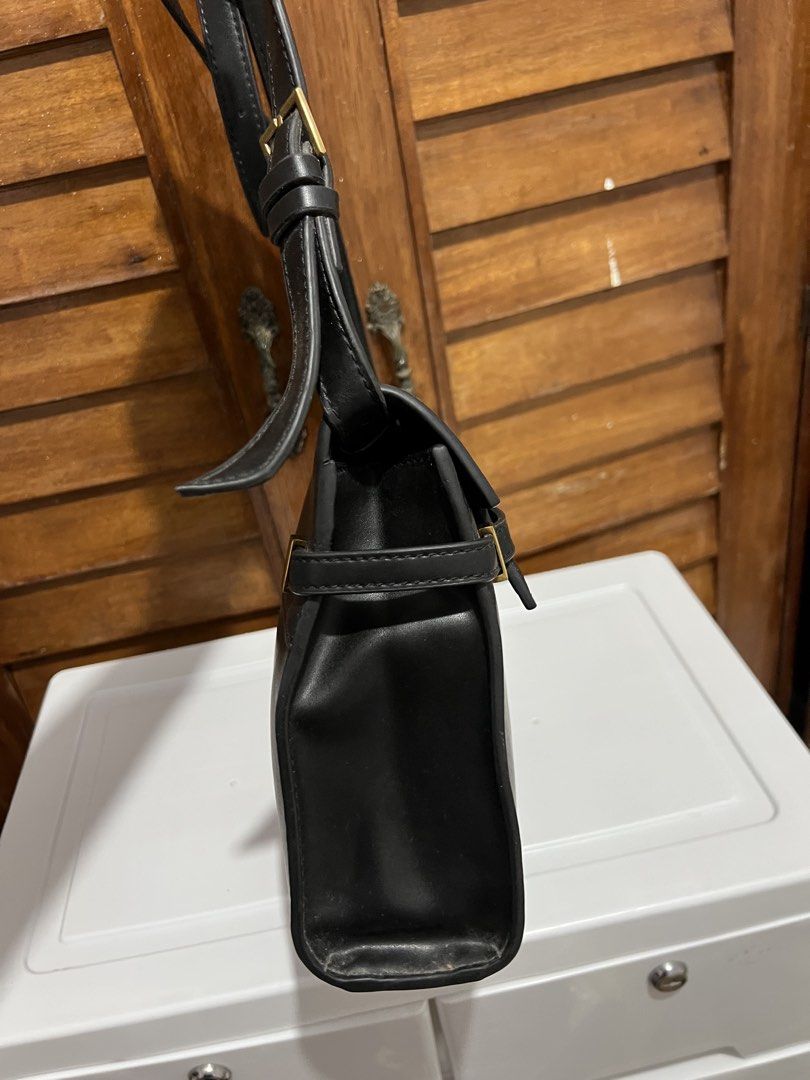 Saint Laurent Paris Black Shoulder Bag (Category: Luxury Bags & Wallets) located in Manila. Submitted by zoeykim16 (Listing ID 1423679199, Image 3). Description: - Saint Laurent shoulder bag - Black leather - Flap closure - Gold-tone metal clasp with Saint Laurent Paris logo - Adjustable shoulder strap - Rectangular shape -NGA only.