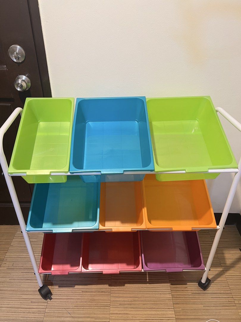 Storage Cart with Bins (Category: Storage Boxes & Baskets) located in Muntinlupa City. Submitted by rigoutmafia (Listing ID 1423745291, Image 1). Description: Storage cart features multiple colorful bins for organizing items. It has a white metal frame with wheels for easy mobility. The cart includes bins in various colors such as green, blue, orange, pink, and purple. One of the purple bins has a visible crack..