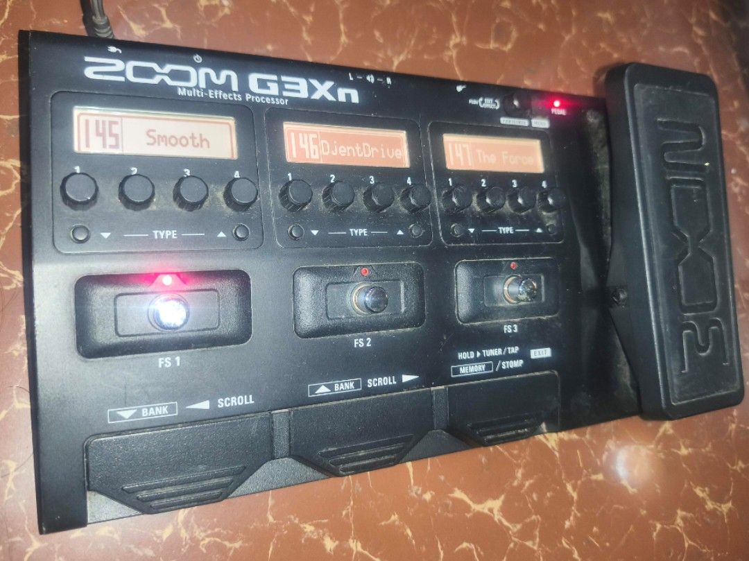 Zoom G3Xn Multi-Effects Processor (Category: Musical Instruments) located in Manila. Submitted by bonsai13 (Listing ID 1423696065, Image 2). Description: Zoom G3Xn multi-effects processor. Features multiple effects, including "Smooth", "SilentDrive", and "The Force". Includes a built-in expression pedal. Displays various effect settings on its screens. The unit has multiple footswitches and control knobs for adjusting effects. Includes a power ca