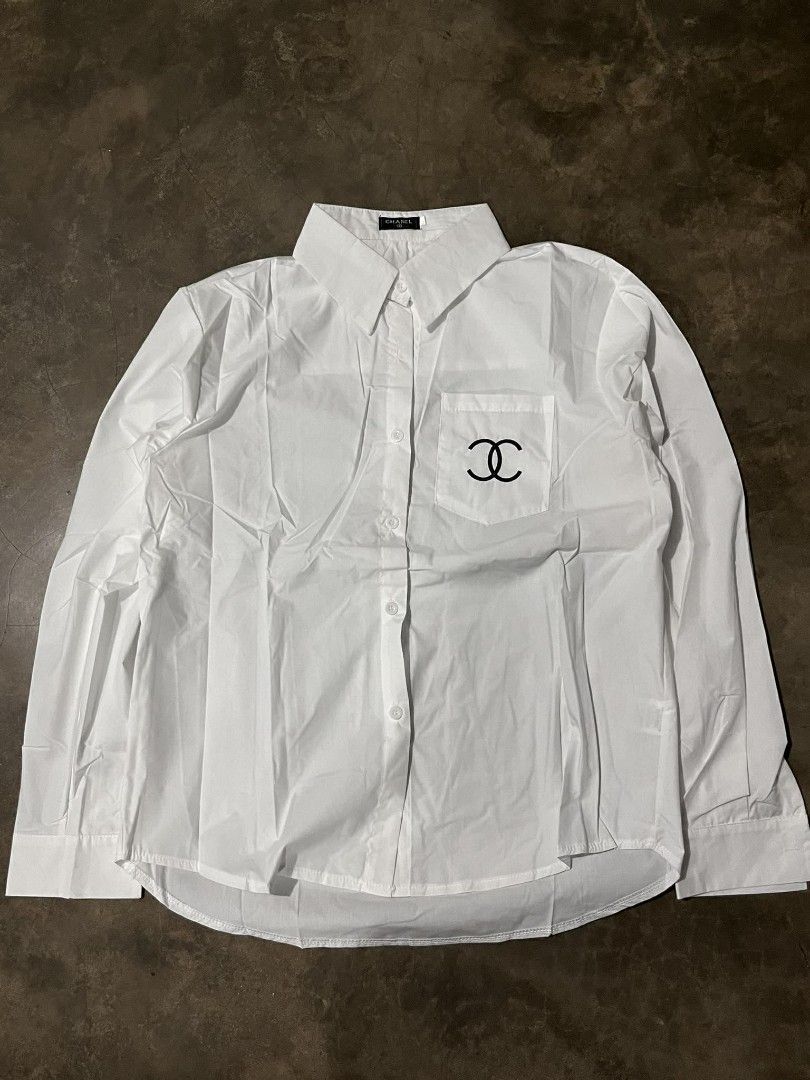 Chanel White Long Sleeve Shirt (Category: Luxury Apparel) located in Manila. Submitted by jaydrenn (Listing ID 1423790964, Image 3). Description: - 21.5/27 - Chanel long sleeve shirt - White color - Chanel logo embroidered on back and pocket - Classic collar - Button-down closure - Chest pocket with Chanel logo - Made in Italy.
