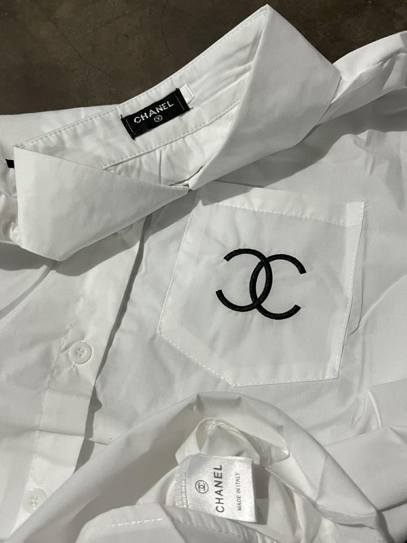 Chanel White Long Sleeve Shirt (Category: Luxury Apparel) located in Manila. Submitted by jaydrenn (Listing ID 1423790964, Image 2). Description: - 21.5/27 - Chanel long sleeve shirt - White color - Chanel logo embroidered on back and pocket - Classic collar - Button-down closure - Chest pocket with Chanel logo - Made in Italy.
