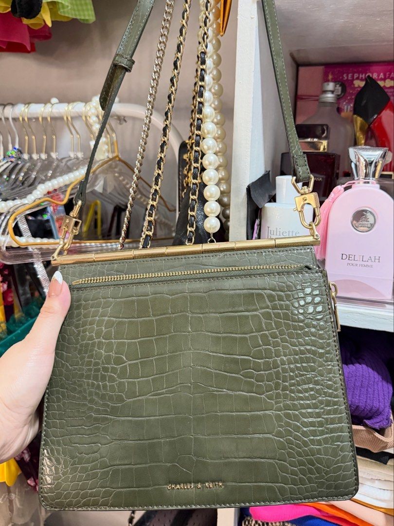 Charles & Keith Green Croc Crossbody Bag (Category: Cross-body Bags) located in Antipolo. Submitted by decluttering.shopph (Listing ID 1423969236, Image 1). Description: Charles & Keith green crossbody bag. Features a croc-embossed finish, gold hardware, and chain strap. Includes top handle, zippered pocket, and compartments. Rectangular shape..