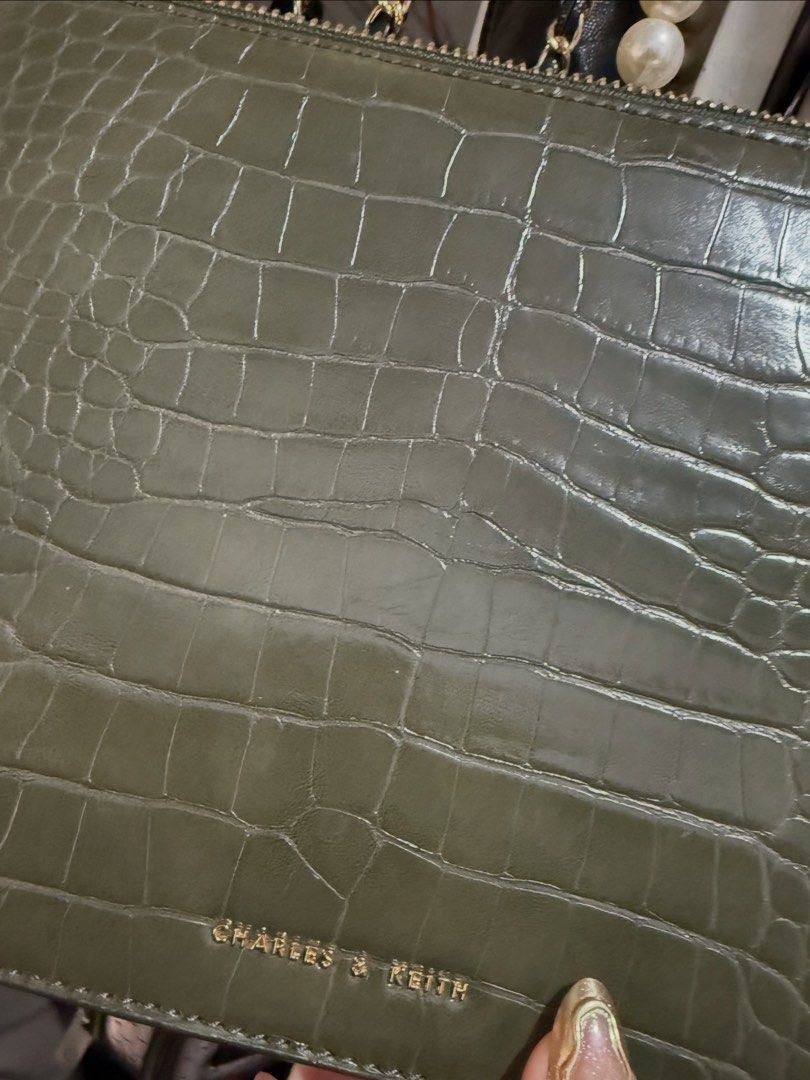 Charles & Keith Green Croc Crossbody Bag (Category: Cross-body Bags) located in Antipolo. Submitted by decluttering.shopph (Listing ID 1423969236, Image 3). Description: Charles & Keith green crossbody bag. Features a croc-embossed finish, gold hardware, and chain strap. Includes top handle, zippered pocket, and compartments. Rectangular shape..