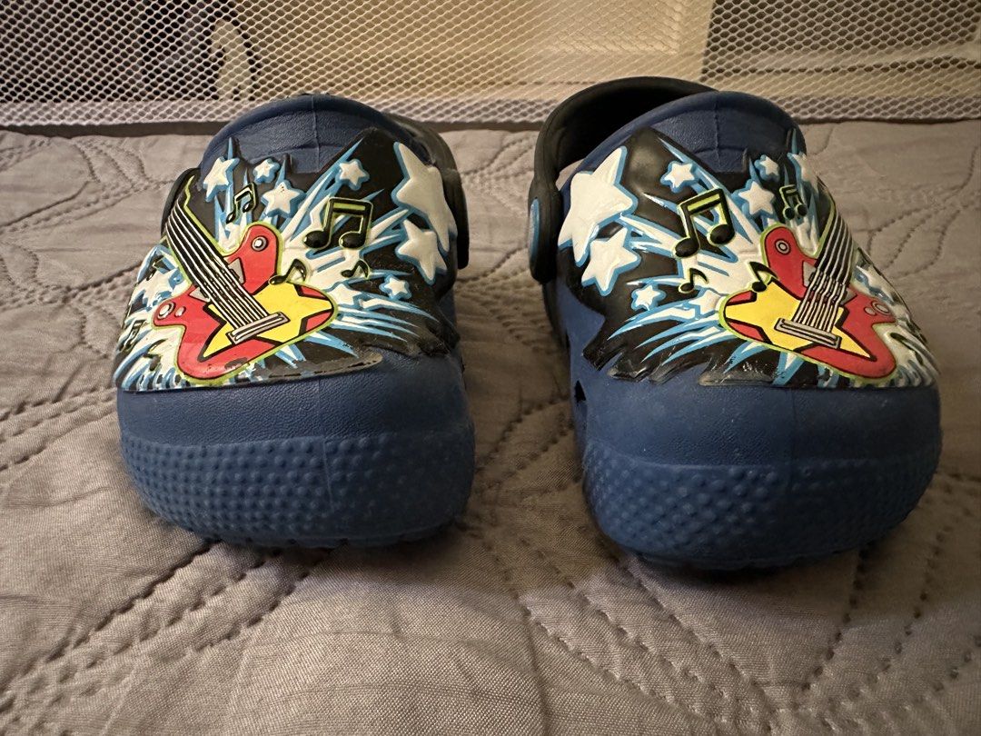 Crocs Kids Clog - Blue (Category: Babies & Kids Fashion) located in Bulacan. Submitted by dyna01 (Listing ID 1423848034, Image 2). Description: - Blue Crocs clogs with a fun guitar design. - Size: C6 - Features a black strap with the Crocs logo. - Made of waterproof material. - Perfect for kids who love music and comfortable shoes. - Lights are still working .