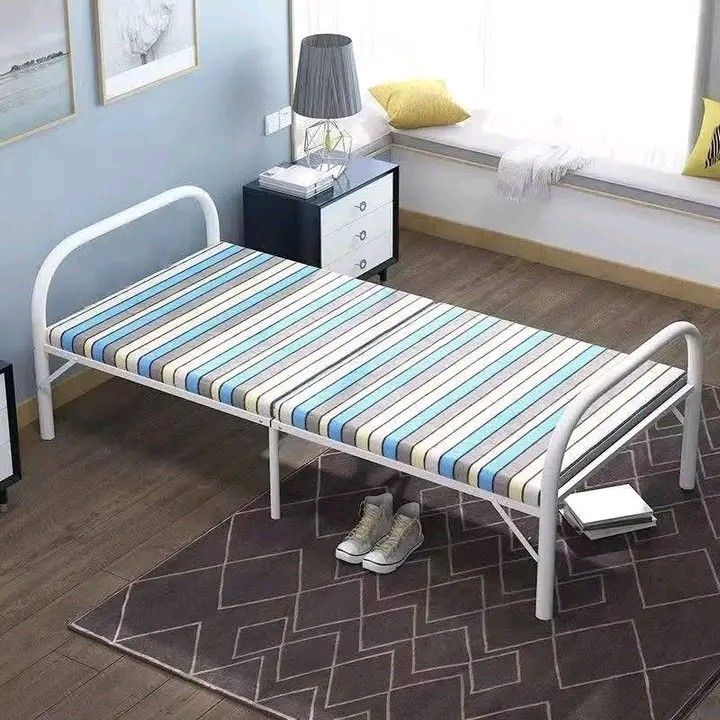 Foldable Single Bed (Category: Bed Frames & Mattresses) located in Makati City. Submitted by oideme (Listing ID 1423831717, Image 2). Description: Foldable single bed is perfect for small spaces. It features a striped mattress and a sturdy white metal frame. The bed is easy to set up and fold away for storage. It requires no installation and is portable. Dimensions are approximately 180cm long, 75cm wide, and 40cm high..