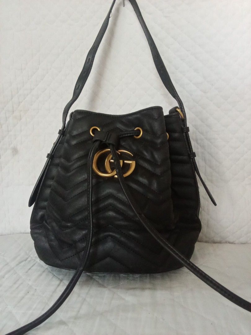 Gucci GG Marmont Bucket Bag (Category: Luxury Bags & Wallets) located in Manila. Submitted by abhie0027 (Listing ID 1423950351, Image 1). Description: Black Gucci GG Marmont bucket bag. Features a drawstring closure, gold-tone hardware, and a chevron quilted design. Includes a shoulder strap. The iconic double G logo is prominently displayed on the front. A stylish and versatile bag for everyday use..