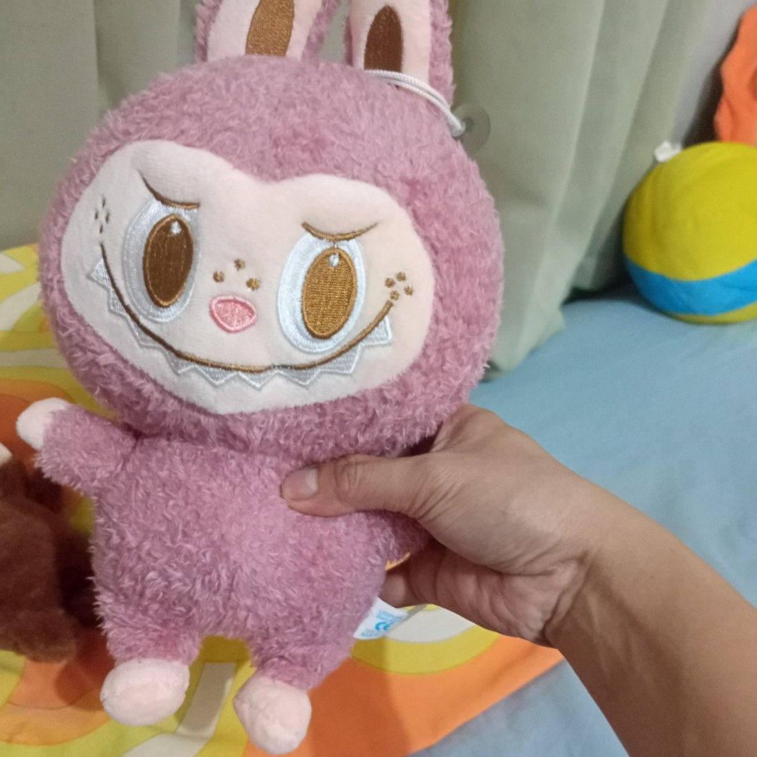 Labubu plush toy set (Category: Plushies & Soft Toys) located in Manila. Submitted by feg39 (Listing ID 1423841657, Image 3). Description: - Adorable plush toy set - Features a brown character: - Available with a guitar - Also available as a keychain - Includes a pink character with long ears - All toys have unique face designs - Perfect for collectors or gifts.