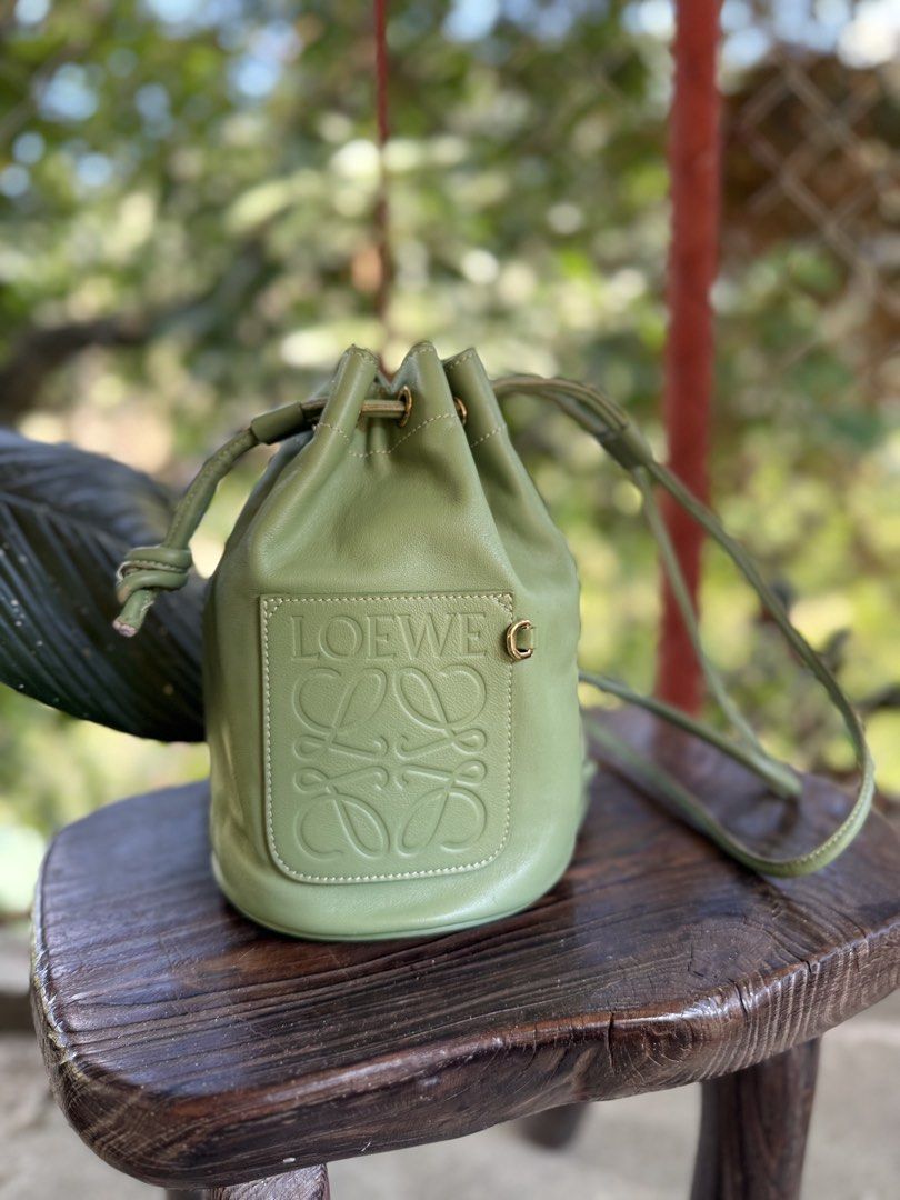 Loewe Small Leather Bucket Bag (Category: Luxury Bags & Wallets) located in Manila. Submitted by fivethousandlilies (Listing ID 1423968830, Image 1). Description: - Authentic Loewe bucket bag - Crafted from green leather - Features embossed Loewe logo - Drawstring closure - Adjustable shoulder strap - Gold-tone hardware - Lined interior with patterned fabric - Made in Spain.