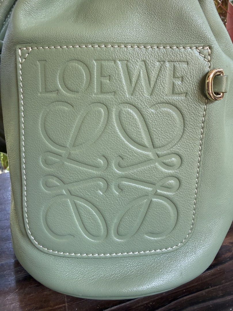 Loewe Small Leather Bucket Bag (Category: Luxury Bags & Wallets) located in Manila. Submitted by fivethousandlilies (Listing ID 1423968830, Image 2). Description: - Authentic Loewe bucket bag - Crafted from green leather - Features embossed Loewe logo - Drawstring closure - Adjustable shoulder strap - Gold-tone hardware - Lined interior with patterned fabric - Made in Spain.
