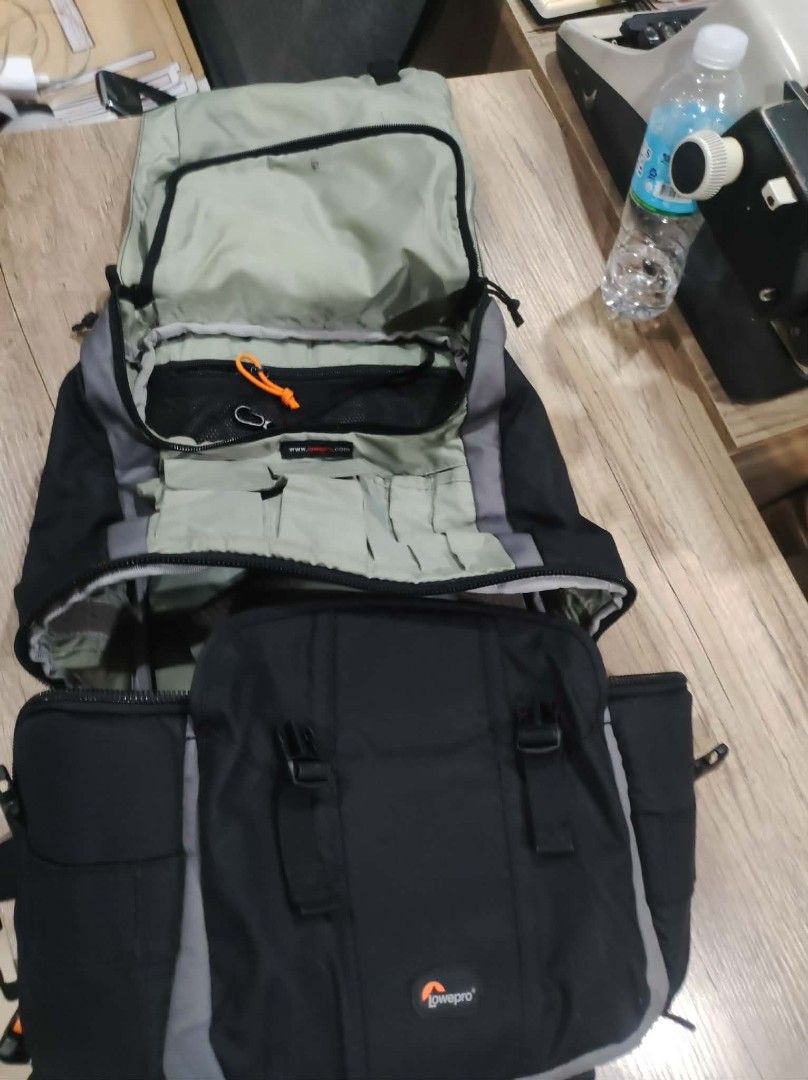 Lowepro bag (Category: Camera Bags & Carriers) located in Surigao. Submitted by thrifttofinds (Listing ID 1423801863, Image 2). Description: - Lowepro camera backpack - Black and gray color scheme - Multiple compartments and pockets for gear organization - Adjustable straps for comfort - Padded back for comfortable carrying - Includes a rain cover - Designed for photographers.