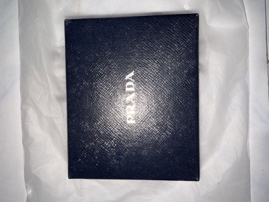 Prada Saffiano Leather Wallet (Category: Luxury Bags & Wallets) located in Manila. Submitted by timokschickenpalabok (Listing ID 1423858457, Image 1). Description: - Authentic Prada wallet - Black Saffiano leather - Includes original box and packaging - Multiple card slots - Bill compartments - Prada logo visible - Classic design.